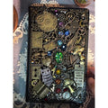 BrassBound Pages Cassian handmade fantasy steampunk journal with clock dial, emerald core and rainbow gem cabochons on an ornate black cover