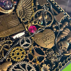 Seraphine Nightwing BrassBound Pages steampunk journal detail with layered gears, “Love” heart plate, pink crystal accent, and scorpion charm on black resin cover